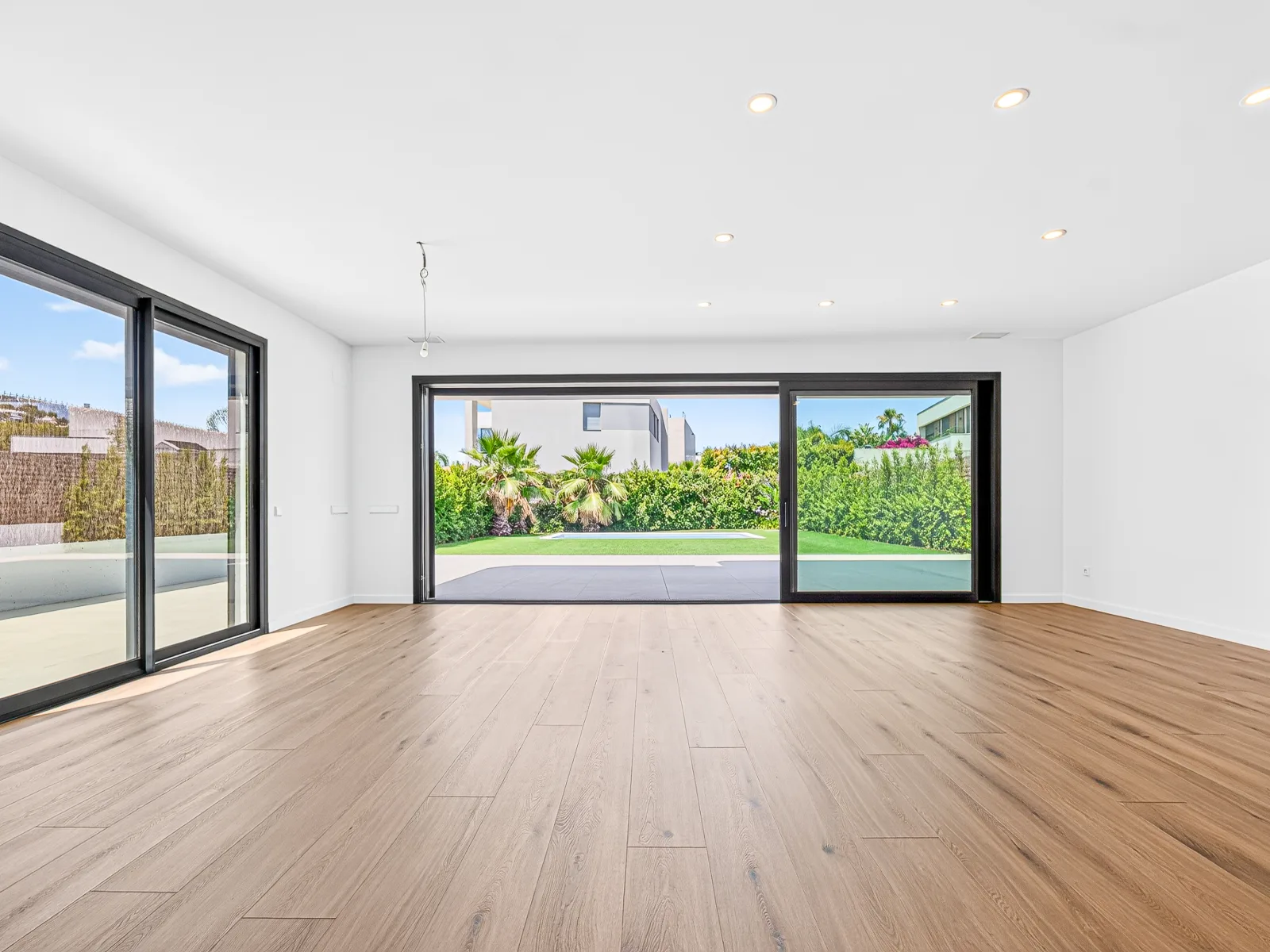 Chalet residencial — salón frontal con ventanal al jardín